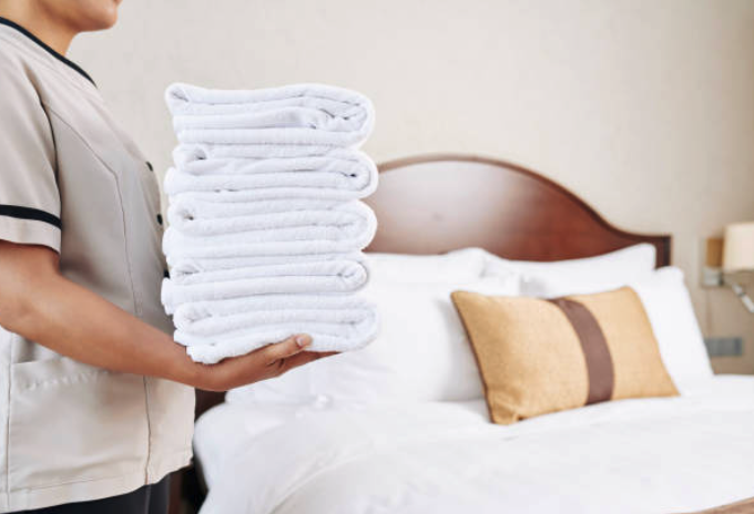 Imagen con una empleada de hotel cargando toallas